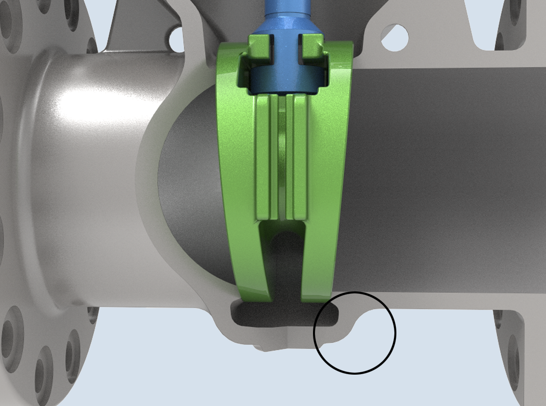 A close-up of a mechanical component featuring a silver cylindrical part with a detailed green and blue joint assembly. A black circle highlights a specific section of the component, indicating an area of interest.